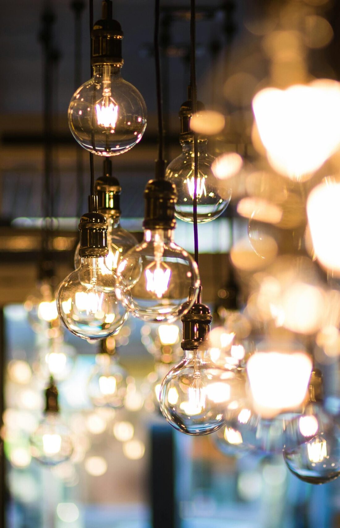 A modern and ambient urban setting with glowing, hanging light bulbs in focus.